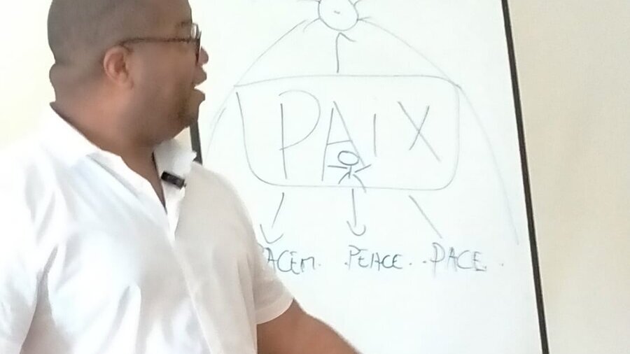 Romaric en moment de transmission devant le tableau Paix